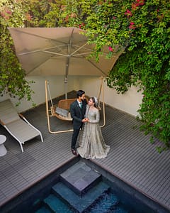 Wide Angle Wedding Portrait at Bougainvillea DHA Phase 8 Bride and groom standing together beside the swimming pool surrounded by bougainvillea flowers at Bougainvillea DHA Phase 8 Karachi.
